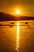 Floatplanes silhouetted on Beluga Lake, Homer, Kenai Peninsula, Southcentral Alaska