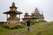 Man hiking past Buddhist Stupas of Nar on the Nar Phu Trek, Nepal, Himalaya, Asia