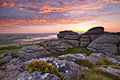 Spectacular sunrise in summer above the granite tor on Meldon Hill, Dartmoor National Park, Devon, England, United Kingdom, Europe