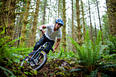 Mountain biking through a lush forest in Vancouver, British Columbia, Canada.