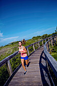 Eine junge Frau trainiert am Strand von Florida.