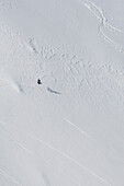 Snowboarder grabbing his board during a late run in Romania at Balea Lake in April