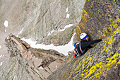 A young man rock  climbing  on the Flying Buttress of Mount Meeker near Chasm Lake, Rocky Mountain National Park, Estes Park, Colorado.