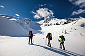 Three climbers head  towards the summit of Joffre Peak, British Columbia, Canada.