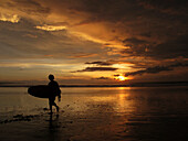 Surfer guy, at the end of the day back to the beach. Ubud Kuta Beach Indonesia