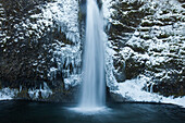 Icy waters of Horestail Creek flow over Horestail Falls in the winter, Columbia River Gorge National Scenic Area, Oregon.