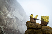 Transport baskets filled with sulfur blocks in the crater of volcano Ijen - Indonesia, Java