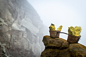 Transportkörbe, gefüllt mit Schwefelblöcken im Krater des Vulkan Ijen - Indonesien, Java