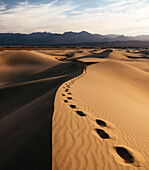 Man walking through Mesquite Sand Dunes at dawn, Death Valley National Park, California, United States of America, North America