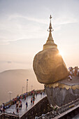 Pilgrims at Golden Rock Stupa Kyaiktiyo Pagoda at sunset, Mon State, Myanmar Burma, Asia