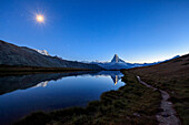 Full moon and Matterhorn illuminated for the 150th anniversary of the first ascent, reflected in Lake Stellisee, Zermatt, Canton of Valais, Swiss Alps, Switzerland, Europe