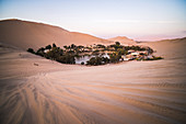 Huacachina and sand dunes at sunset in the desert in the Ica Region, Peru, South America