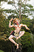 Statue of dancing deity in lush forest