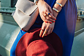 Caucasian woman holding hat and purse