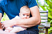 Mann hat Baby auf dem Arm, blaue Augen, Kleinkind, Boipeba, Bahia, Brasilien