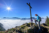 Frau trägt sich in Gipfelbuch ein, Nebelmeer im Inntal und Mangfallgebirge mit Wendelstein im Hintergrund, Rehleitenkopf, Mangfallgebirge, Bayerische Alpen, Oberbayern, Bayern, Deutschland