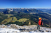 Woman hiking looking towards Seefeld Plateau and Karwendel, valley of Inn in background, view from Hohe Munde, Hohe Munde, Mieming Range, Tyrol, Austria