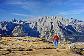 Woman hiking towards Schneibstein, Hundstod and Watzmann in background, view from Schneibstein, Schneibstein, Berchtesgaden Alps, Upper Bavaria, Bavaria, Germany