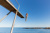 Diving tower at the beach near Hullehavn Camping, girl jumping, summer, Baltic sea, Bornholm, Svaneke, Denmark, Europe