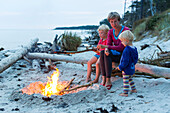 Familiy, mother and two children sitting around a campfire, adventure, dream beach between Strandmarken und Dueodde, sandy beach, summer, Baltic sea, Bornholm, Strandmarken, Denmark, Europe, MR