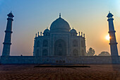 Sun rising behind one of the minarets of the Taj Mahal without a cloud in the sky, Agra, Uttar Pradesh, India