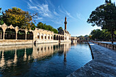 Chamber of Abraham and a minaret reflected in the tranquil water of a lake, Sanliurfa, Turkey