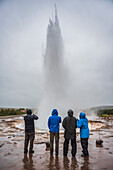 Tourists watching Strokkur Geyser erupt, Geysir, The Golden Circle, Iceland, Polar Regions