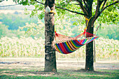 Hammock between two young oaks in a shady French garden, France, Europe