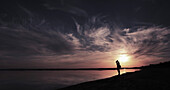 Silhouette man standing at lake shore during sunset, Aydar lake, Uzbekistan