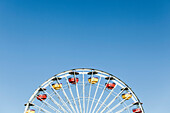 Low angle view of Ferris wheel against clear blue sky