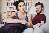 Portrait of young woman with man relaxing in bed