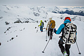 Skiers descend a ridge after climbing to a summit in the Coast Mountains during the Spearhead Traverse in Whistler, British Columbia, Canada.