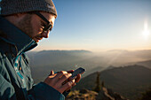 A man uses his smartphone while enjoying the outdoors.