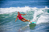 Surfer girl catches wave in high heels.