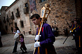 An altar boy holds a lump during Easter Holy Week in Caceres, Extremadura, Spain
