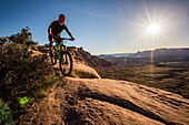 A man mountain biking on the Captian Ahab trail, Moab, Utah.