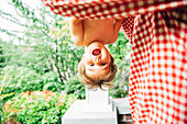 Baby boy hanging upside down outdoors