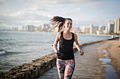 Mixed race amputee athlete jogging on urban waterfront