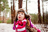 Caucasian girl catching snow on tongue