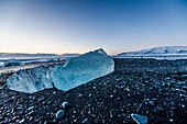 Joekulsarlon, Growler on the beach at sunrise, Glacierlagoon, Vatnajoekull Glacier, Winter, Iceland