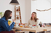Smiling couple having breakfast at home