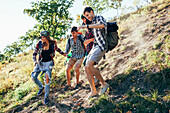 Low angle view of friends climbing mountain in forest