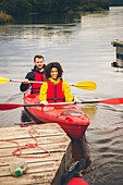Happy man and woman kayaking on lake