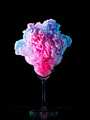 Abstract image of multi colored frozen yogurt in glass against black background