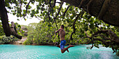 Besucher schwingt mit einem Seil in die Blue Lagoon auf der Insel Efate