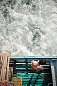 sailor washing himself at the back of the ship, Ko Phayam, Andaman coast, Thailand, Southeast Asia