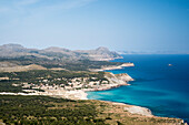 Vom Gipfel des Berges Es Telégraf oberhalb des Cap des Freu blickt man auf das tiefblaue Meer und die Häuser von Cala Mesquida, im Hintergrund die Berge von Cap Formentor, Nordostküste von Mallorca, Balearen, Spanien