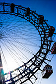 The Ferris wheel, big wheel in the Vienna Prater, Wiener Prater, Amusement Park, against sunlight and clear blue sky, Vienna, Austria