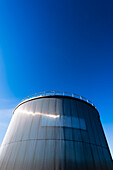 A big silvery gas or tank of an industrial plant against blue sky, Hamburg, Germany