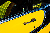Vintage American car with flashy yellow painting and cube as doorbolt, Ft. Myers, Florida, the USA